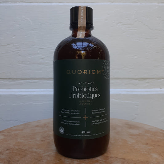 Bottle of Guorion Probiotics on a wooden surface with a white wall background